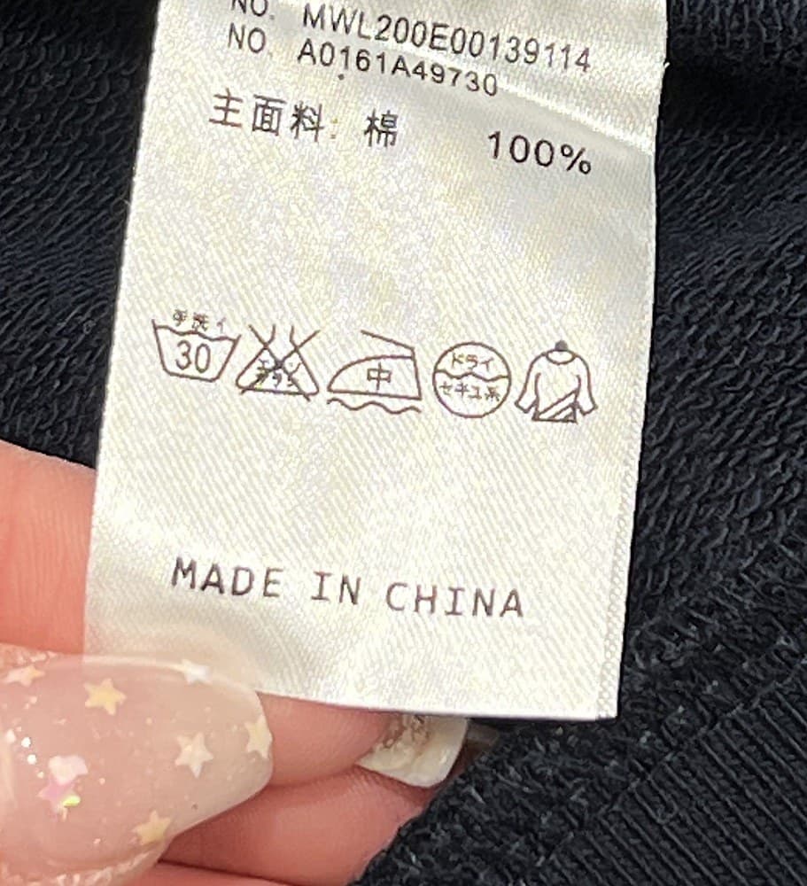 Counterfeit country-of-origin tag — "MADE IN CHINA," with a product number format and multilingual layout not consistent with mainline Thom Browne labelling