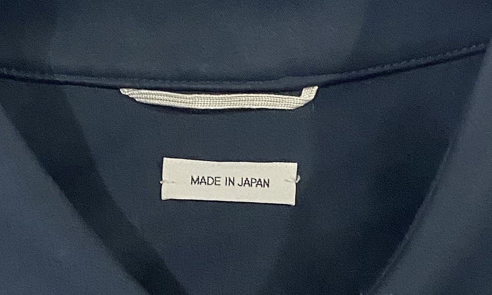 Genuine Thom Browne country-of-origin label — a simple "MADE IN JAPAN" tag sewn beneath the main woven brand label