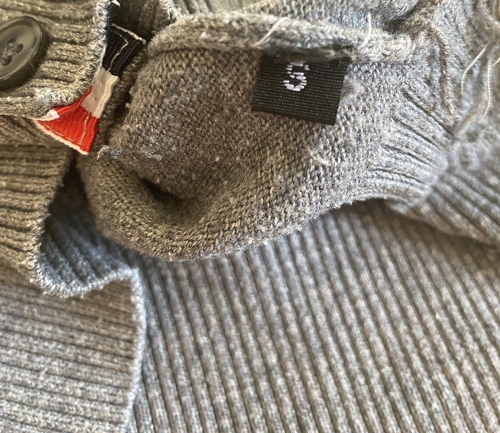 Counterfeit interior placket — no branded tag at all, just a small unbranded black size tag, with a thinner and muddier tricolor trim