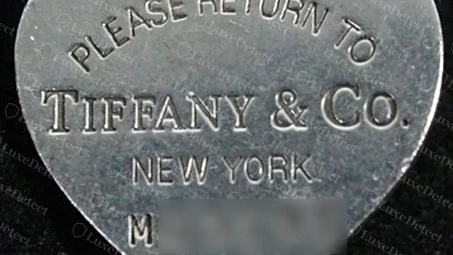 Placa de corazón original con un número de registro con prefijo de letra debajo de NEW YORK (dígitos difuminados, porque el número pertenece a la pieza de un cliente) y 925 en la anilla