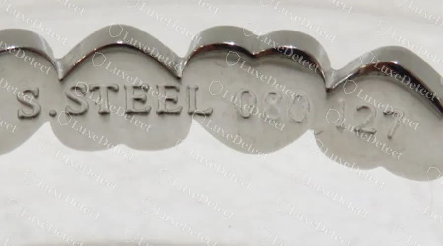 Inside the same counterfeit bangle: the links are stamped S.STEEL, so the 750 gold mark on the front is false