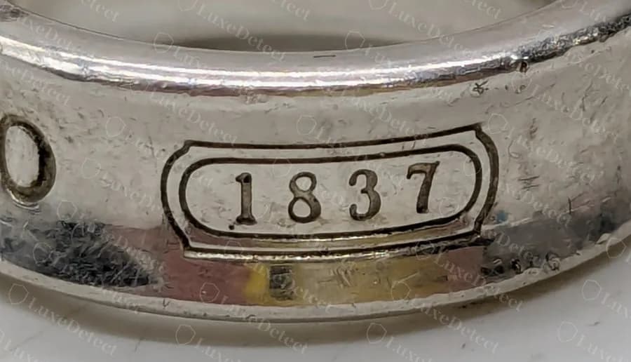 Genuine 1837 cartouche on a band ring: the numerals sit inside a rounded rectangle that has a second, fainter outline around it.