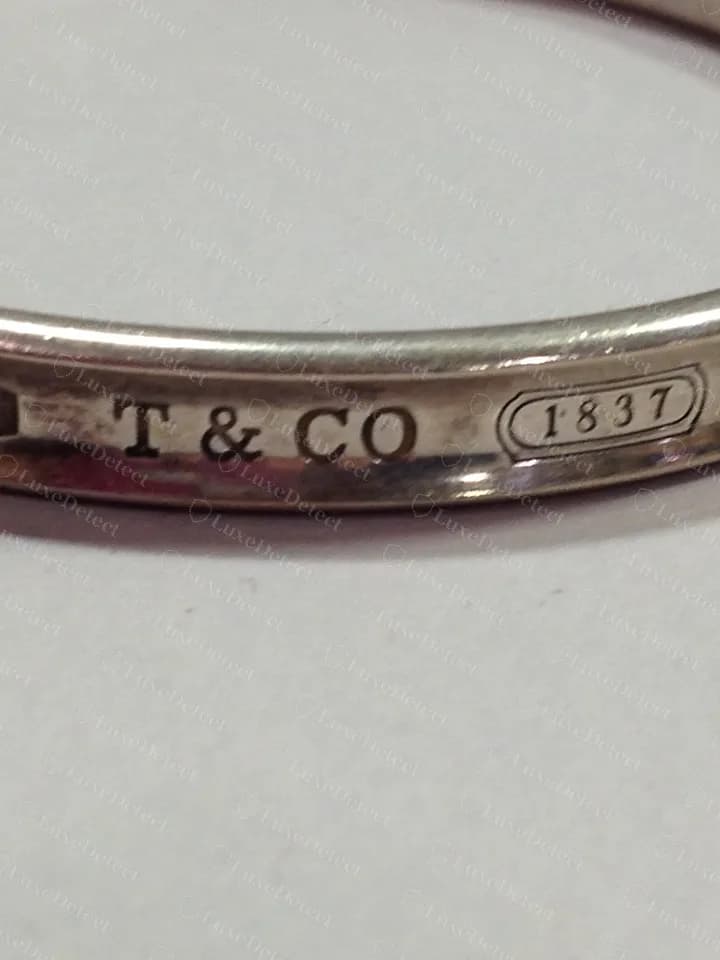 Genuine 1837 bangle: T&CO and the 1837 cartouche on the outside, in the same heavy serif face as the rings.