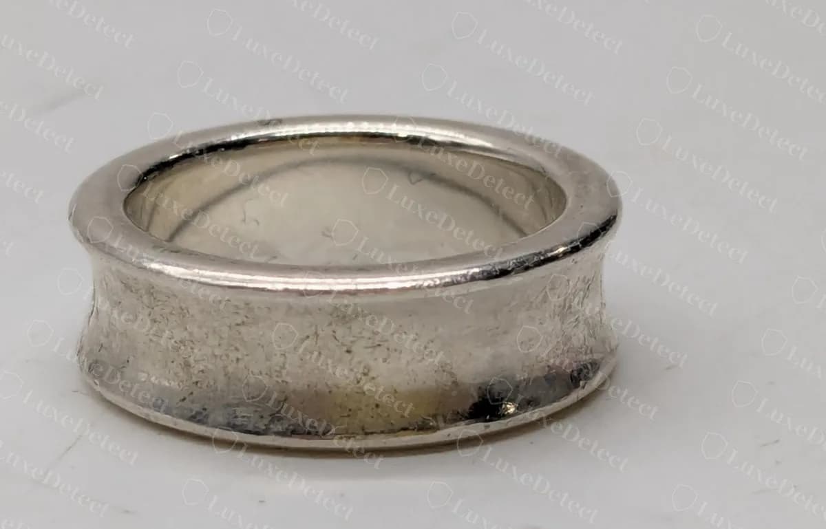 Genuine Tiffany 1837 narrow concave band ring, seen from the front, with the plain concave outer surface that carries the stamp row.