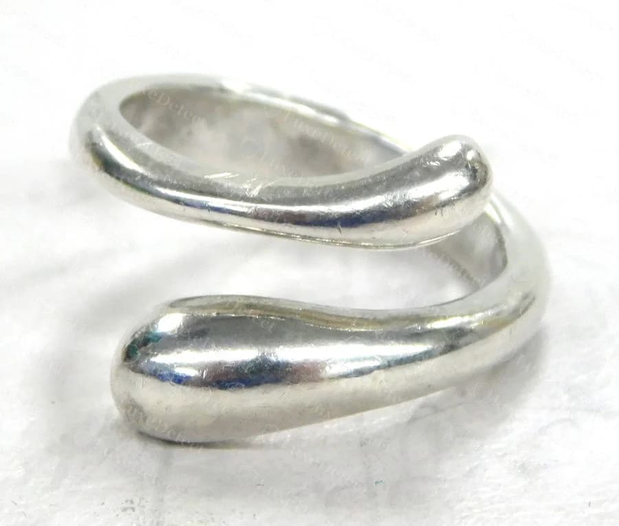 Counterfeit Teardrop Bypass Ring with mismatched terminal drop sizes, a pinched wrap at the overlap, and a patchier surface finish than the genuine piece