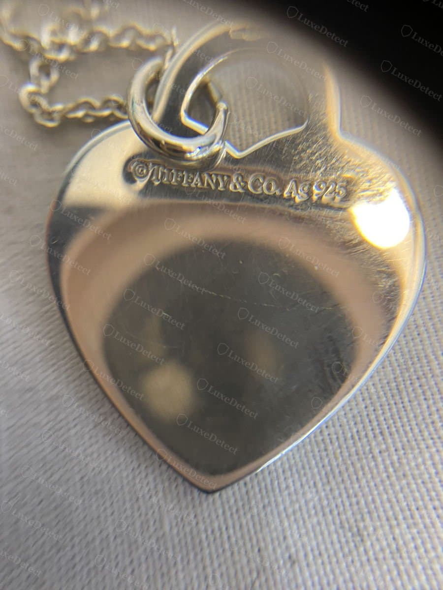 Authentic "©TIFFANY & CO. Ag925" stamp on the back of a heart tag pendant.