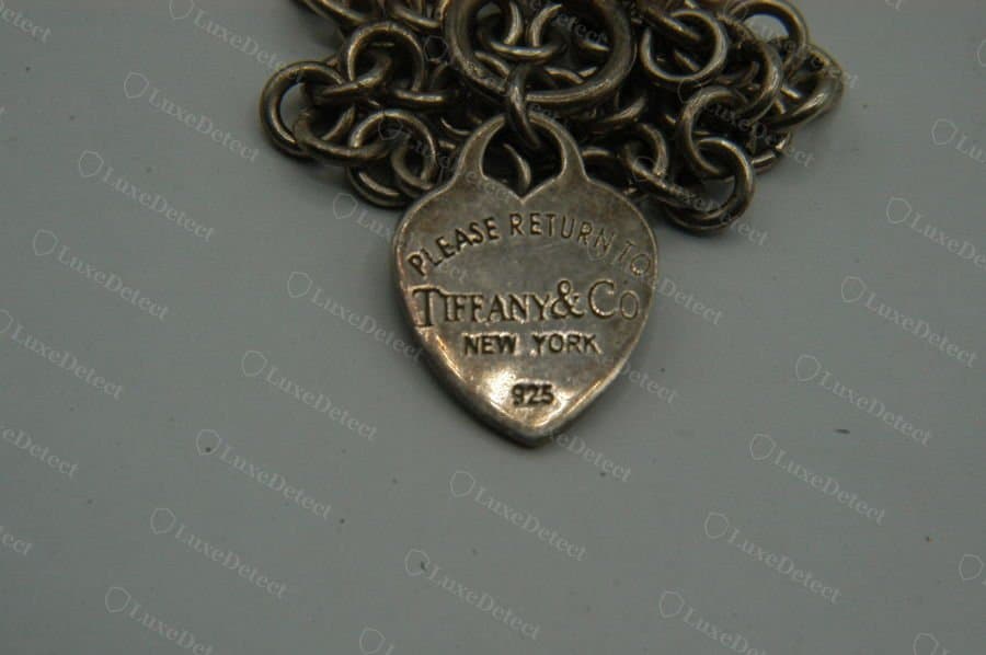 A heavily tarnished counterfeit heart tag from our archive. The engraving font and layout are close enough to genuine that this alone will not resolve the piece.