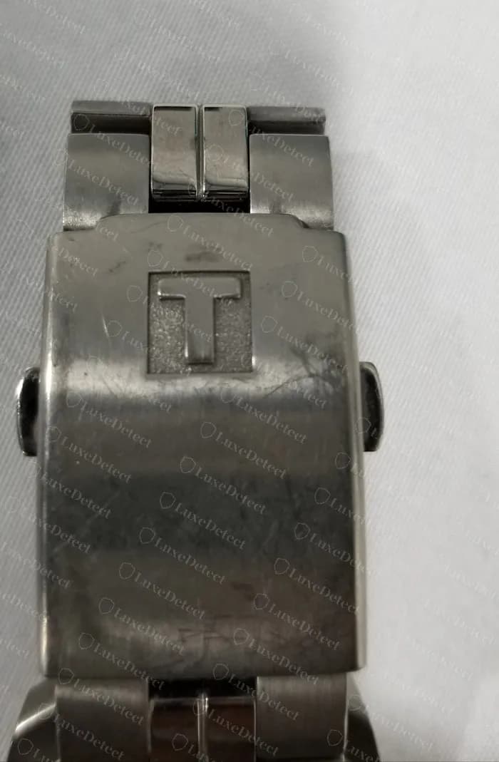 Fecho Tissot original com o logo T em relevo na tampa, numa pulseira de titânio de um PR 100.
