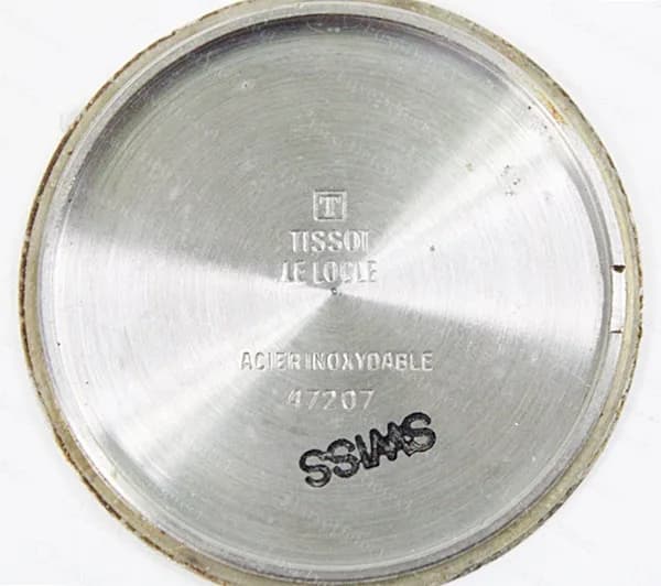 Fondo de un Tissot Seastar vintage de cuarzo: el logotipo T sobre TISSOT LE LOCLE, ACIER INOXYDABLE, un número de caja y un sello SWISS.