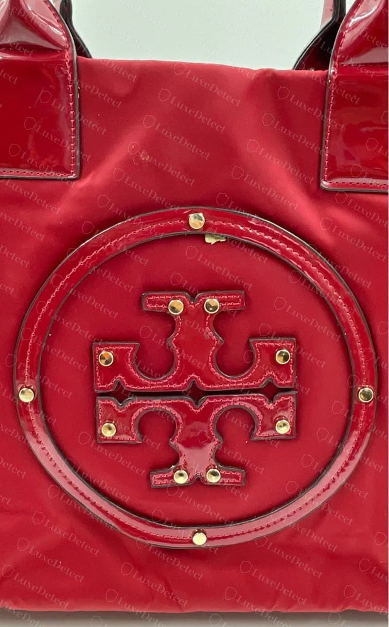 Tote Tory Burch Ella falso: la Double T y el anillo exterior son piezas de charol rojo separadas, cada una sujeta con tachuelas de metal doradas