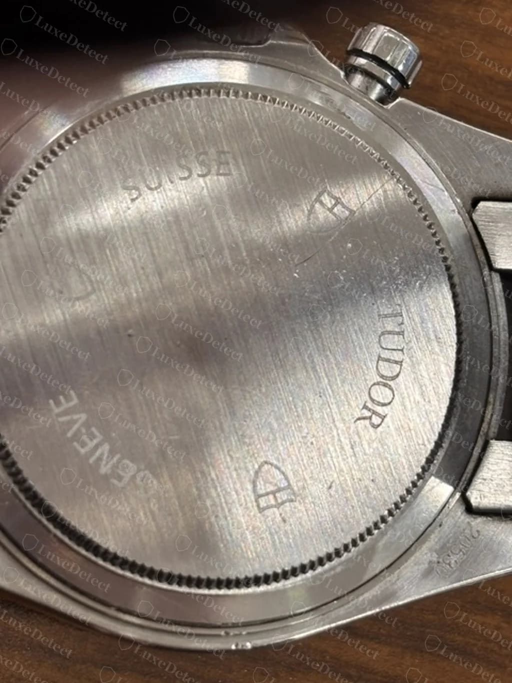 Gefälschter Tudor-Grantour-Chrono-Gehäuseboden: eine flache Platte mit TUDOR, GENEVE und SUISSE mit Schild-Logos und einer am Bandanstoß gestempelten Referenznummer, am selben Exemplar wie das Zifferblatt oben.