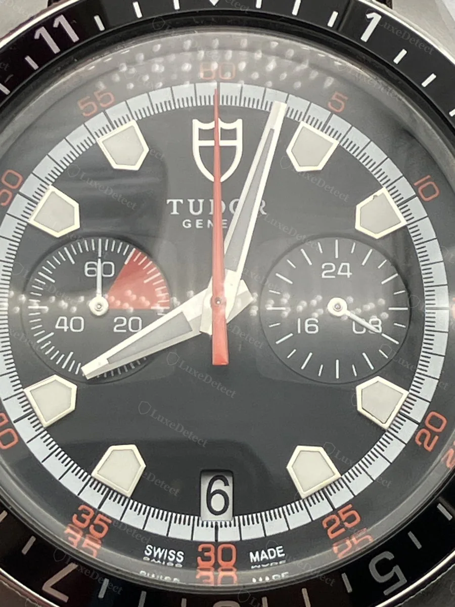 Fake Tudor Grantour Chrono dial, black colorway: pentagon hour markers, twin subdials, and the red-tipped central chronograph hand.
