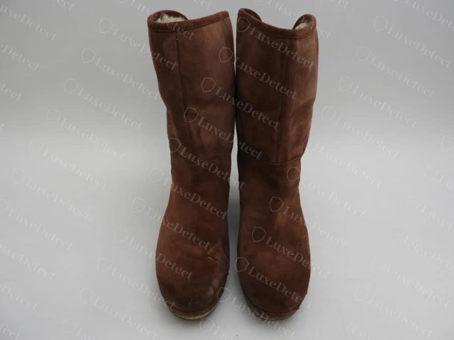A genuine pair of UGG Classic-style short boots in brown suede, showing the overall silhouette, cuff shape, and sole profile