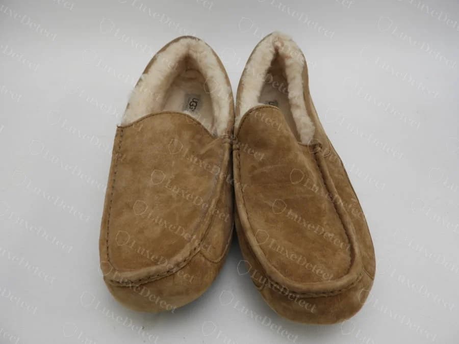 A genuine UGG moccasin-style slipper in tan suede with sheepskin lining, showing the overall proportions and stitched seams