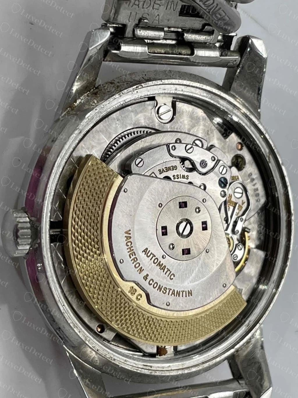 Eine echte Vintage-Automatikuhr von Vacheron & Constantin, durch den Gehäuseboden gesehen: ein goldfarbener Rotor mit gewebter Struktur und der Gravur „Automatic Vacheron & Constantin“ über einem veredelten Stahlwerk.