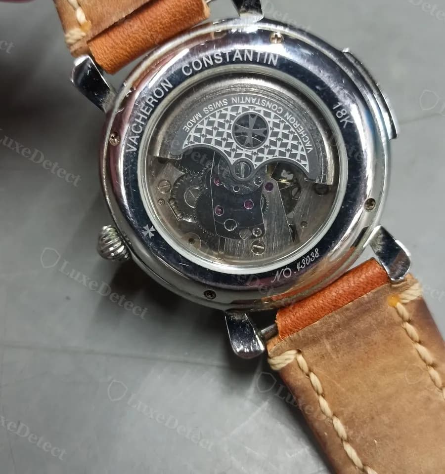 A fake caseback with two rings of text: the outer ring ("VACHERON CONSTANTIN · 18K") reads correctly, but the inner ring around the Maltese cross medallion is mirror-reversed.
