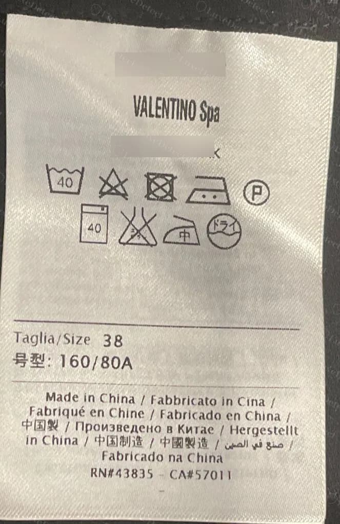 Etiqueta de cuidados original de um vestido Red Valentino feito na China, com o mesmo layout VALENTINO Spa, linhas de tamanho e números RN e CA