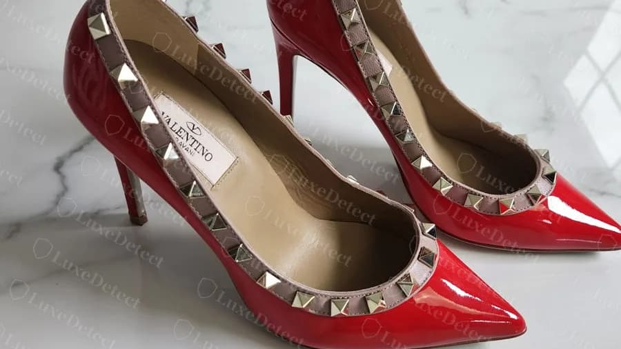 Salón Rockstud genuino de charol rojo con tachones en todo el borde superior y la etiqueta de la plantilla con el logo V