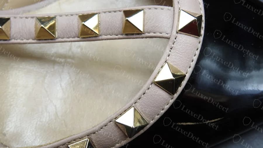 Rockstud strap macro on a black patent pump, pyramid studs with defined facets and a clean apex, set evenly along the nude leather strap
