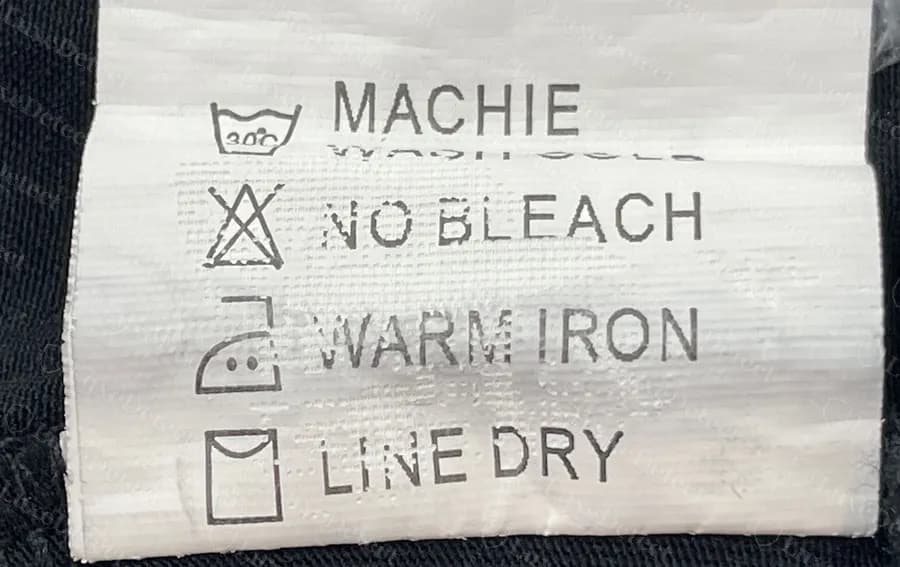 Counterfeit Versace wash tag in broken English: MACHIE, NO BLEACH, WARM IRON, LINE DRY