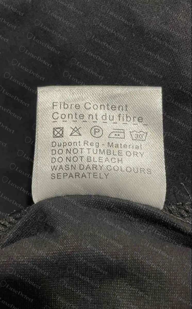 The second tag on the same counterfeit: Fibre Content, Content du fibre, Dupont Reg Material and wash lines with errors such as DO NOT TUMBLE ORY and WASN DARY COLOURS