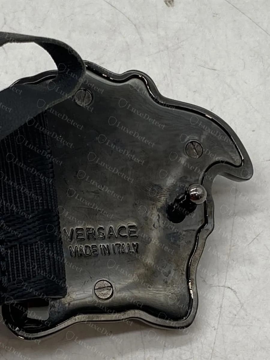 Authentic La Medusa buckle back: flat plate with slotted screws, the pin, and VERSACE MADE IN ITALY stamped beside it