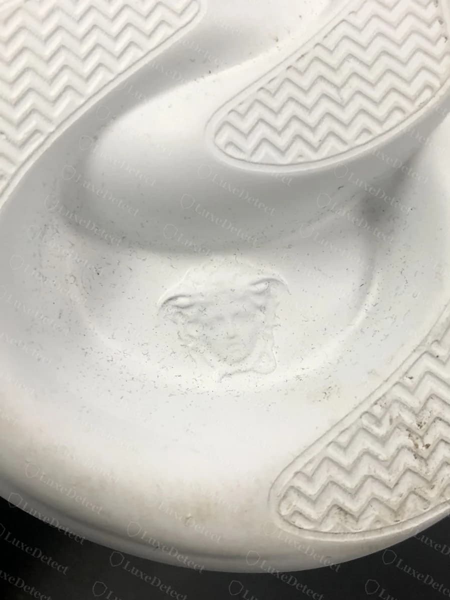 Authentic heel Medusa medallion, debossed into the leather counter with legible facial detail.