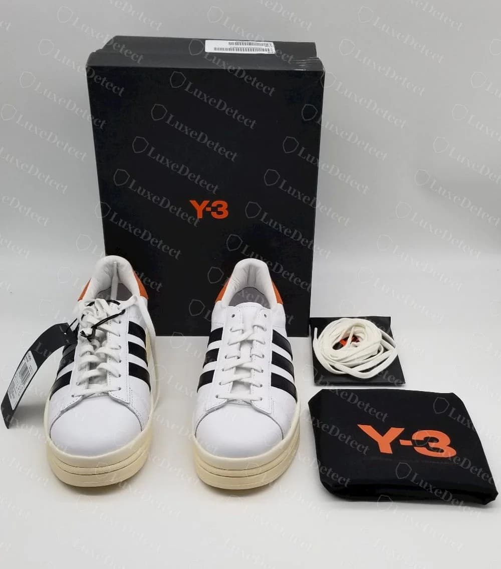 Genuine Y-3 Hicho sneakers with a black box printed with an orange Y-3 logo, a black Y-3 dust bag, spare laces and a black hang tag