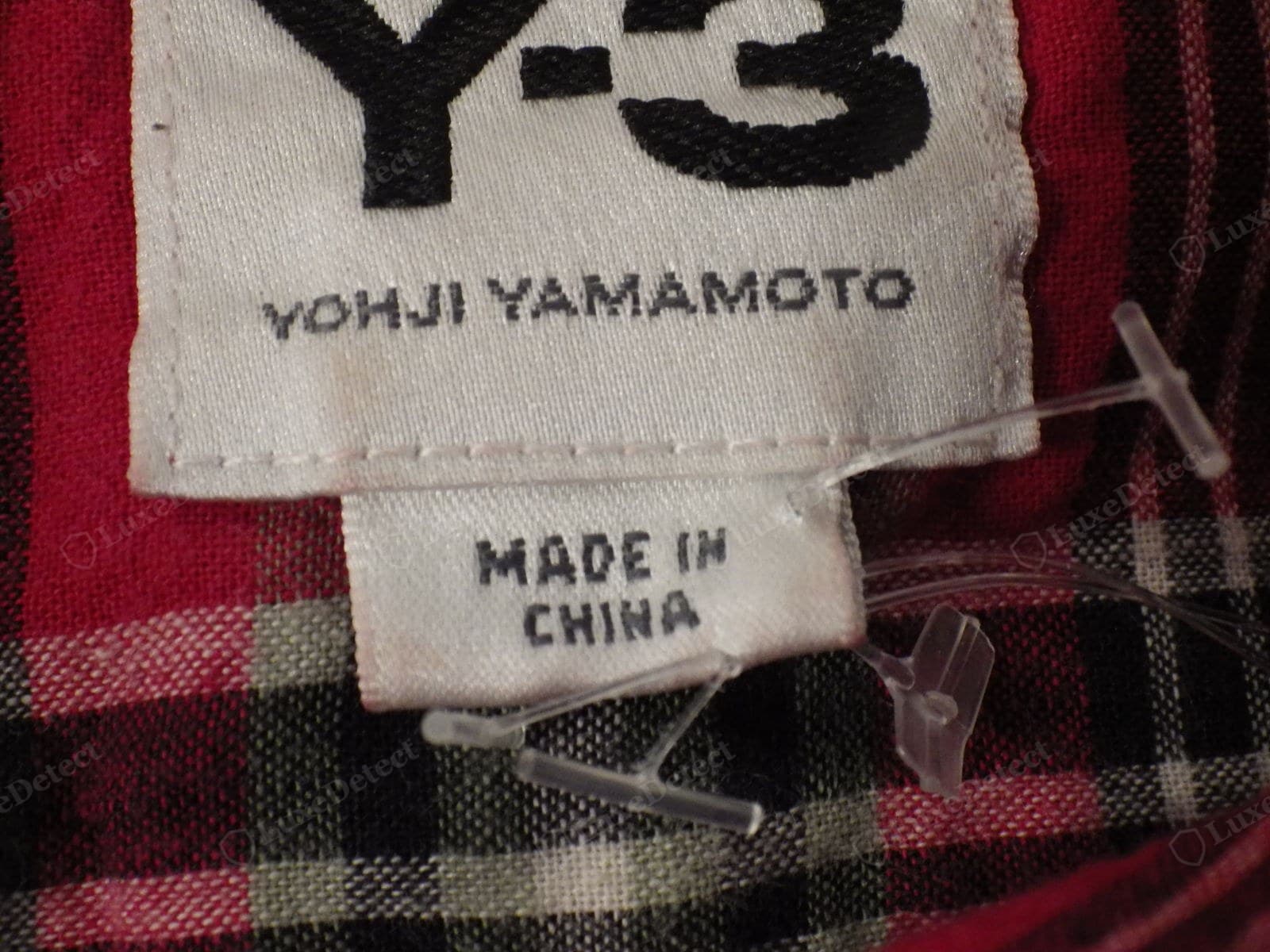 Genuine Yohji Yamamoto Y-3 label — a densely woven "Y-3" logo with "YOHJI YAMAMOTO" printed sharply beneath it, and a separate "MADE IN CHINA" origin tag (correct for the adidas-made Y-3 line)