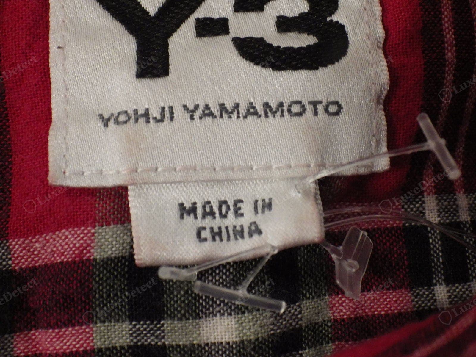 Genuine Yohji Yamamoto Y-3 label — a densely woven "Y-3" logo with "YOHJI YAMAMOTO" printed sharply beneath it, and a separate "MADE IN CHINA" origin tag (correct for the adidas-made Y-3 line)
